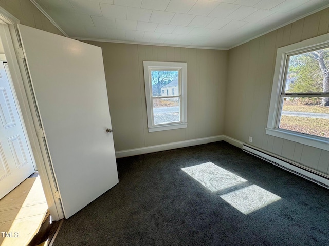 212 Craig Ave, Henderson, NC 27537 - unfurnished room with crown molding, a wealth of natural light, dark carpet, and a baseboard radiator