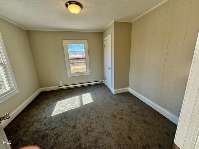 212 Craig Ave, Henderson, NC 27537 - spare room featuring baseboards, a baseboard heating unit, dark colored carpet, and ornamental molding