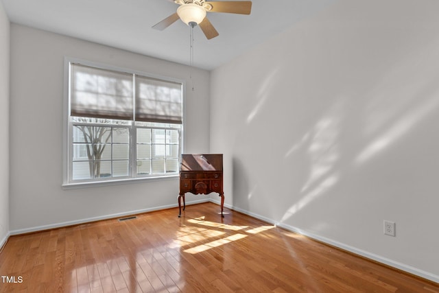 unfurnished room featuring visible vents, ceiling fan, light wood-style flooring, and baseboards