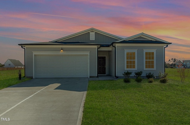 view of front facade with a garage, a yard, and driveway