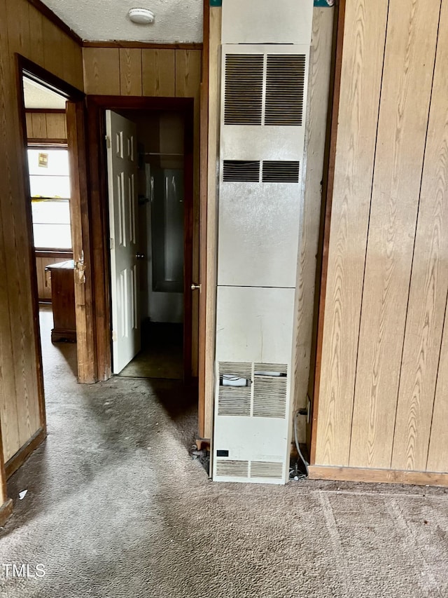 interior space featuring carpet floors, a heating unit, and wooden walls