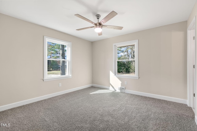 spare room featuring a healthy amount of sunlight, ceiling fan, and carpet floors