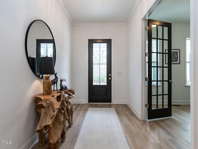 foyer featuring ornamental molding, baseboards, and light wood finished floors