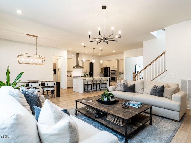 living room with recessed lighting, an inviting chandelier, visible vents, and light wood-style floors