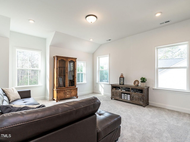 living area with light colored carpet, plenty of natural light, visible vents, and baseboards