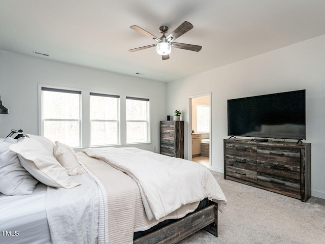 bedroom featuring ceiling fan, connected bathroom, light colored carpet, visible vents, and baseboards