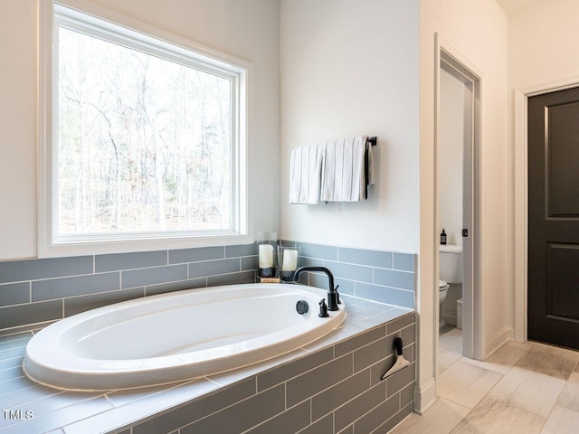 bathroom featuring a bath and toilet