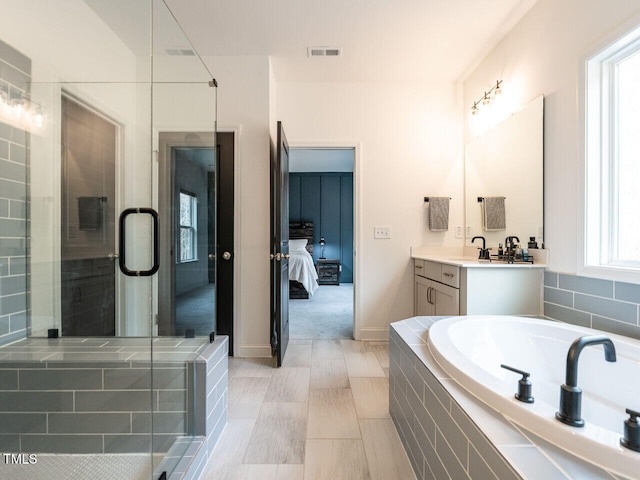 ensuite bathroom with visible vents, baseboards, ensuite bathroom, vanity, and a shower stall