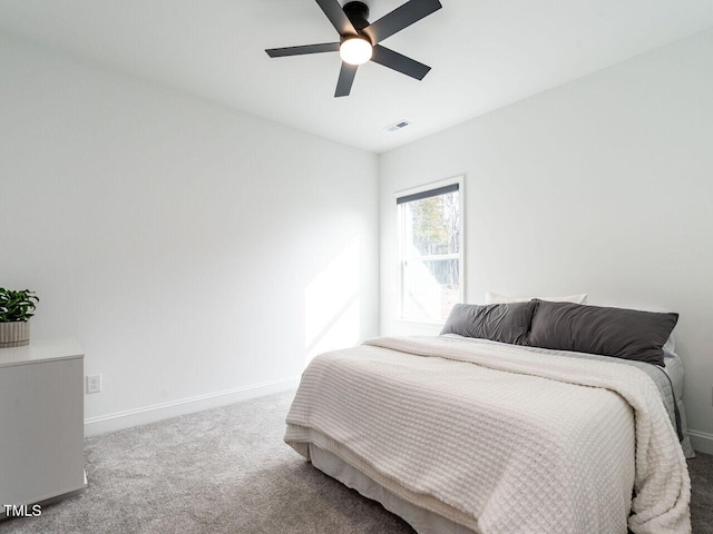 carpeted bedroom with visible vents, baseboards, and a ceiling fan