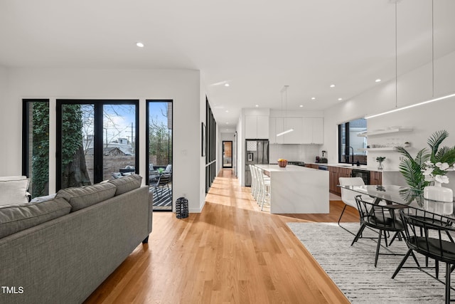 living area featuring light wood finished floors, plenty of natural light, and recessed lighting