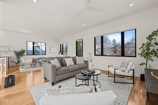 living area featuring light wood finished floors, ceiling fan, baseboards, and recessed lighting