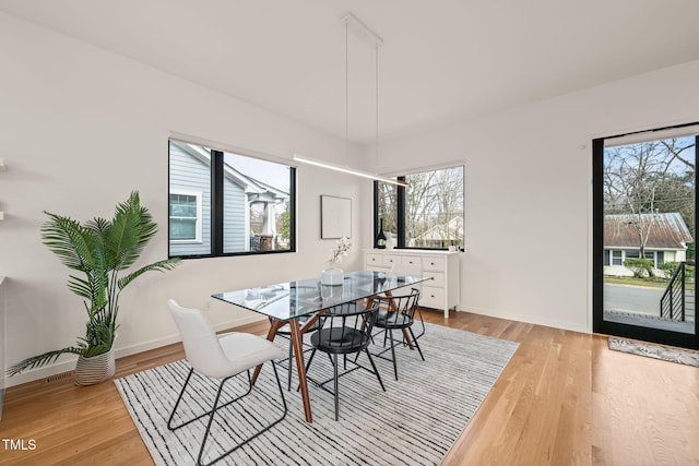 dining room with light wood-type flooring and baseboards