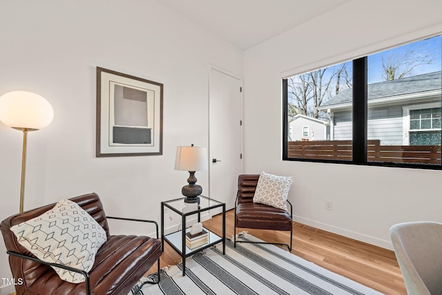 sitting room with baseboards and wood finished floors