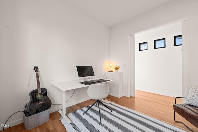 office area with baseboards and wood finished floors