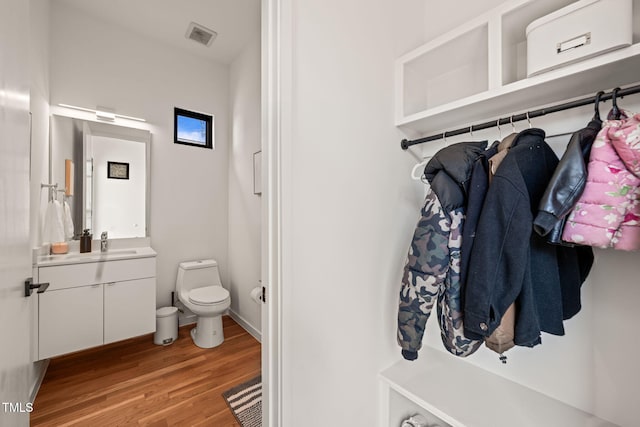 bathroom featuring visible vents, vanity, wood finished floors, and toilet