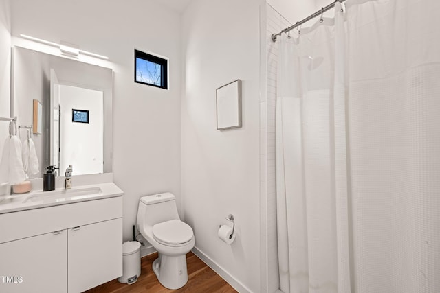 full bathroom featuring curtained shower, toilet, vanity, wood finished floors, and baseboards