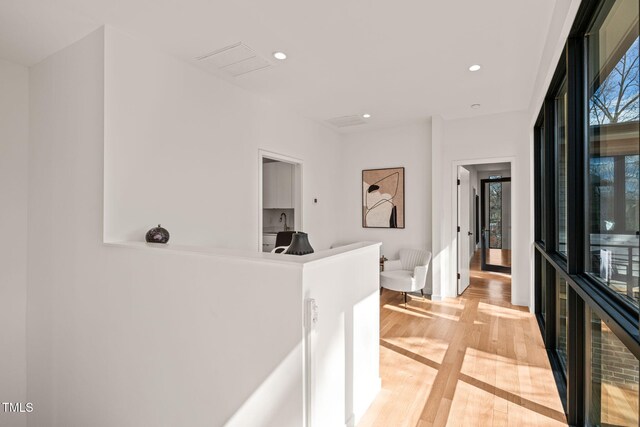 corridor with light wood finished floors and recessed lighting