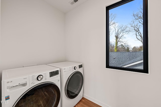 laundry room with laundry area, visible vents, separate washer and dryer, and a wealth of natural light