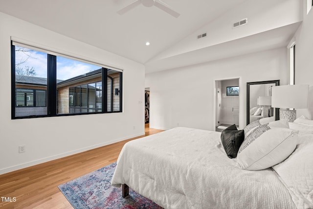 bedroom with vaulted ceiling, wood finished floors, visible vents, and baseboards