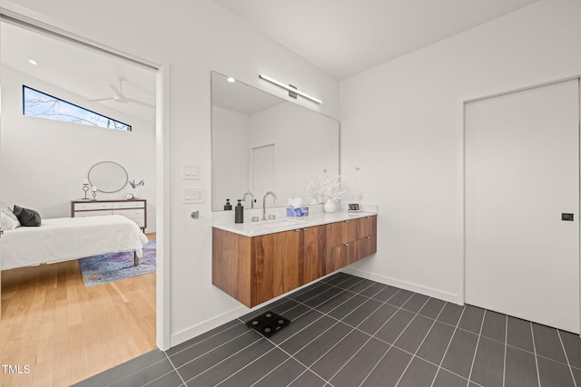 ensuite bathroom with baseboards, a ceiling fan, ensuite bathroom, tile patterned floors, and vanity