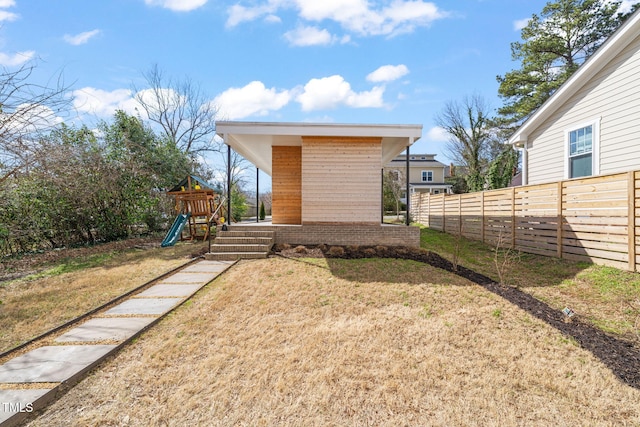 exterior space featuring a playground and fence