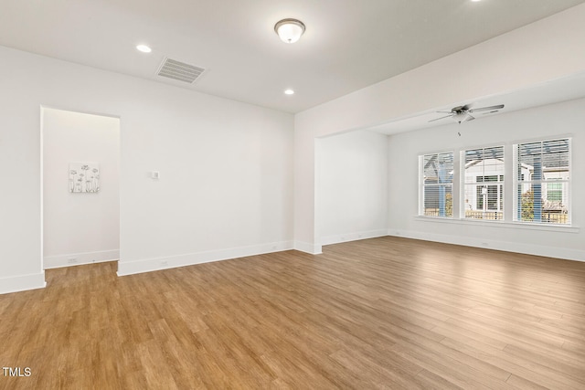 unfurnished room featuring light wood-style floors, visible vents, baseboards, and a ceiling fan