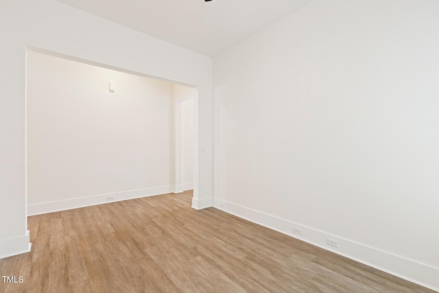 spare room featuring light wood finished floors and baseboards