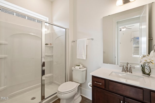 bathroom featuring toilet, a shower stall, ceiling fan, and vanity