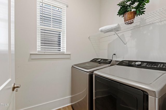 laundry area with laundry area, baseboards, and separate washer and dryer