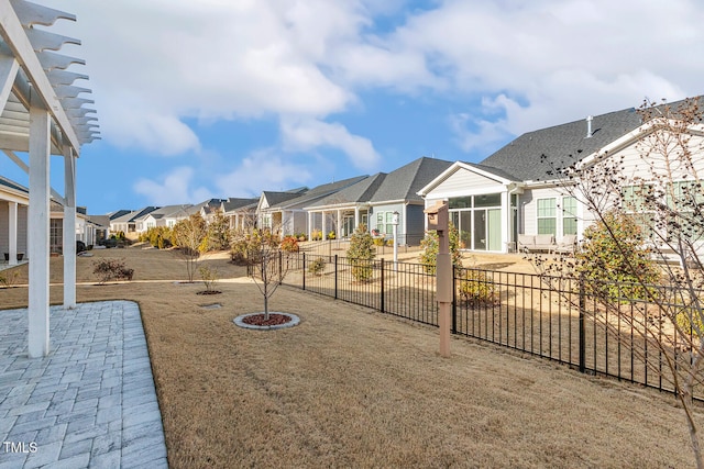 view of yard with a patio, fence, and a residential view