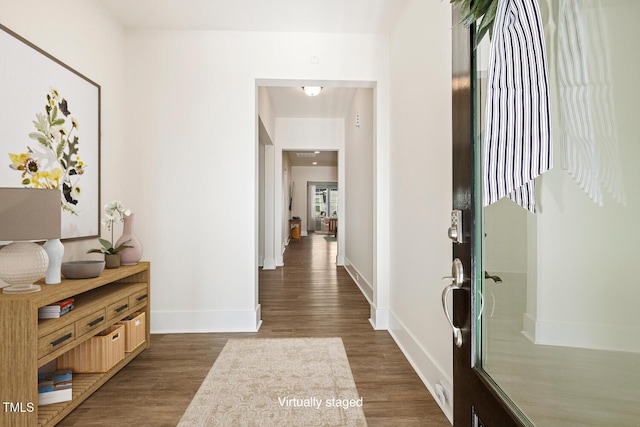 interior space with baseboards and dark wood-type flooring