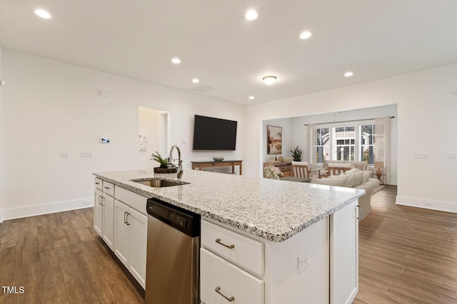 kitchen featuring white cabinets, open floor plan, dark wood-type flooring, stainless steel dishwasher, and a sink