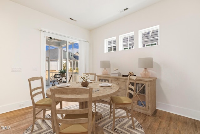 dining area with visible vents, baseboards, and wood finished floors