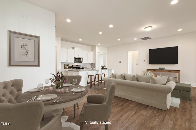 living room featuring recessed lighting, visible vents, and wood finished floors