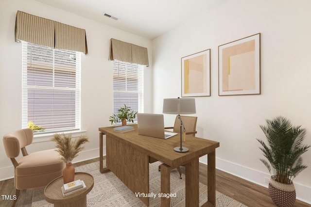 office area with visible vents, plenty of natural light, baseboards, and wood finished floors