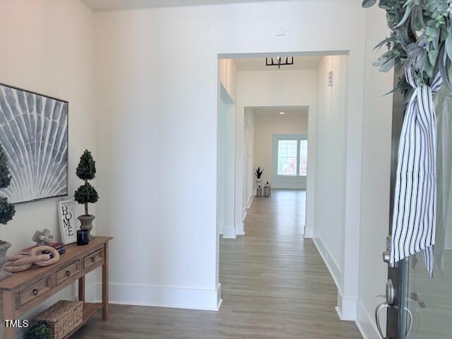 hallway with wood finished floors and baseboards