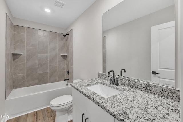 full bathroom with toilet, vanity, tiled shower / bath combo, and wood-type flooring