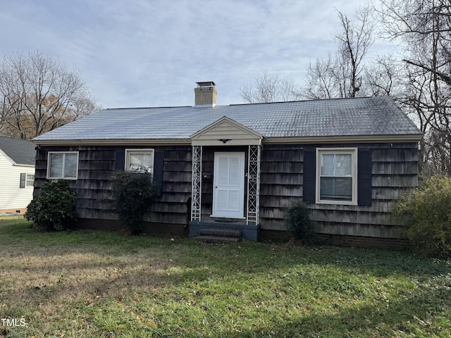 ranch-style house with a chimney, entry steps, and a front yard