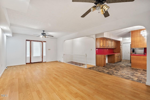 620 Mcghees Mill Rd, Roxboro, NC 27574 - unfurnished living room with visible vents, light wood-style floors, baseboards, arched walkways, and a ceiling fan