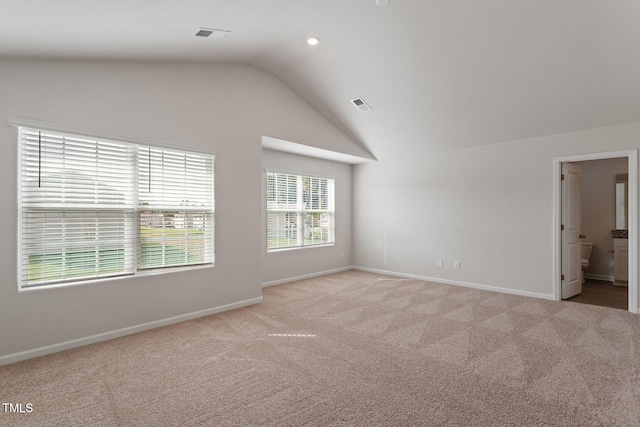 carpeted spare room with lofted ceiling