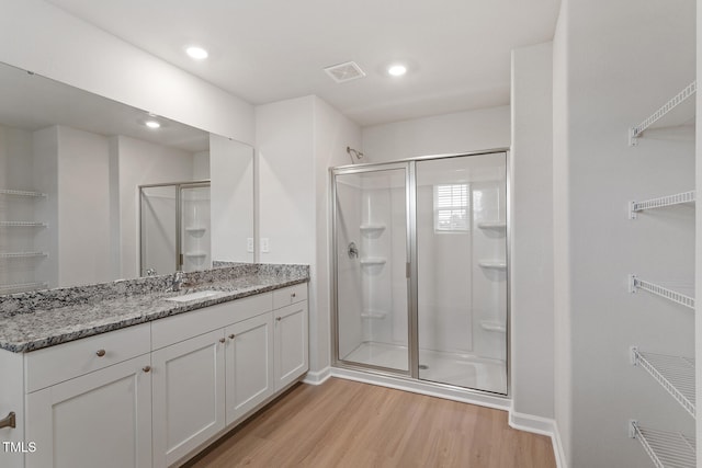 bathroom featuring a shower with door, hardwood / wood-style floors, and vanity