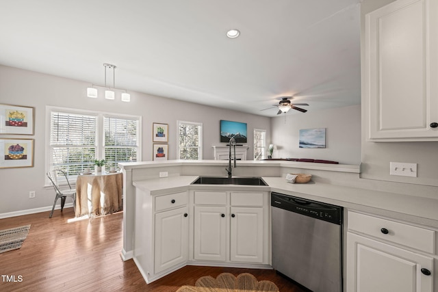 kitchen with dishwasher, a peninsula, light countertops, and white cabinetry