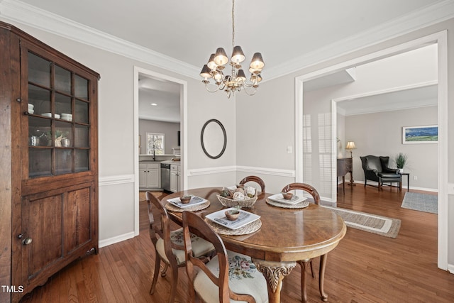 dining space featuring an inviting chandelier, baseboards, dark wood finished floors, and crown molding