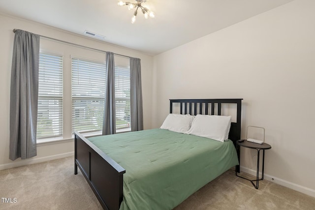 bedroom featuring baseboards, visible vents, and light colored carpet