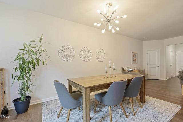 dining room with baseboards, dark wood-style flooring, and a notable chandelier