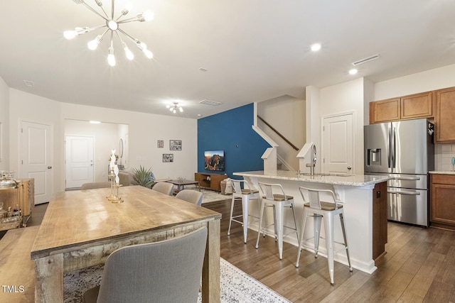 dining room featuring dark wood-style floors, stairs, visible vents, and an inviting chandelier