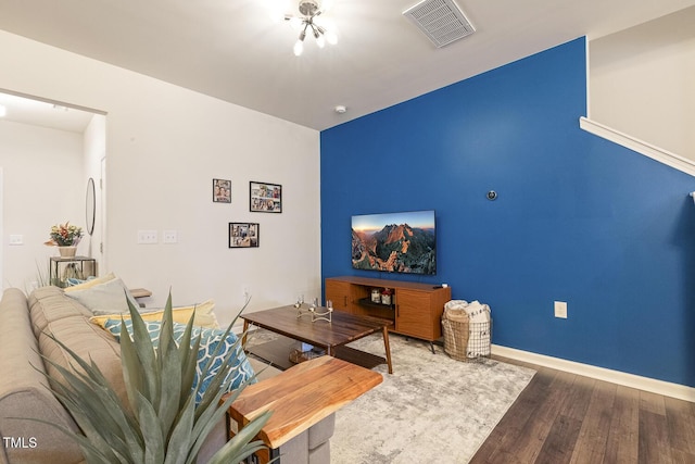 living area with visible vents, baseboards, and wood finished floors