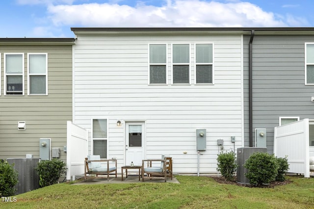 rear view of property featuring a patio area, central AC, and a yard