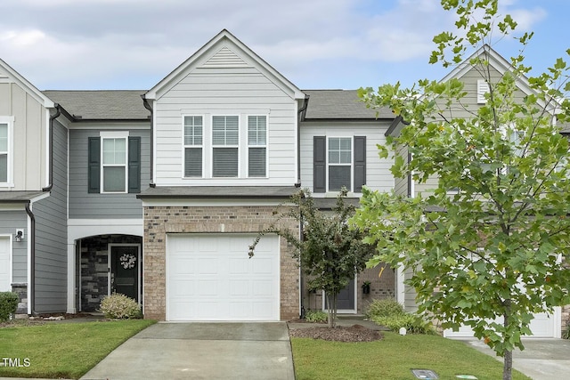 view of property featuring a garage, brick siding, driveway, roof with shingles, and a front lawn