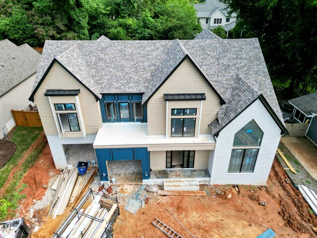 405 Latimer Rd, Raleigh, NC 27609 - view of front facade featuring roof with shingles, a standing seam roof, a fenced backyard, and a metal roof